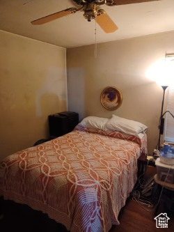 Bedroom with a ceiling fan and wood finished floors