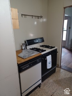 Kitchen featuring range with gas stovetop, dishwasher, and speckled floor