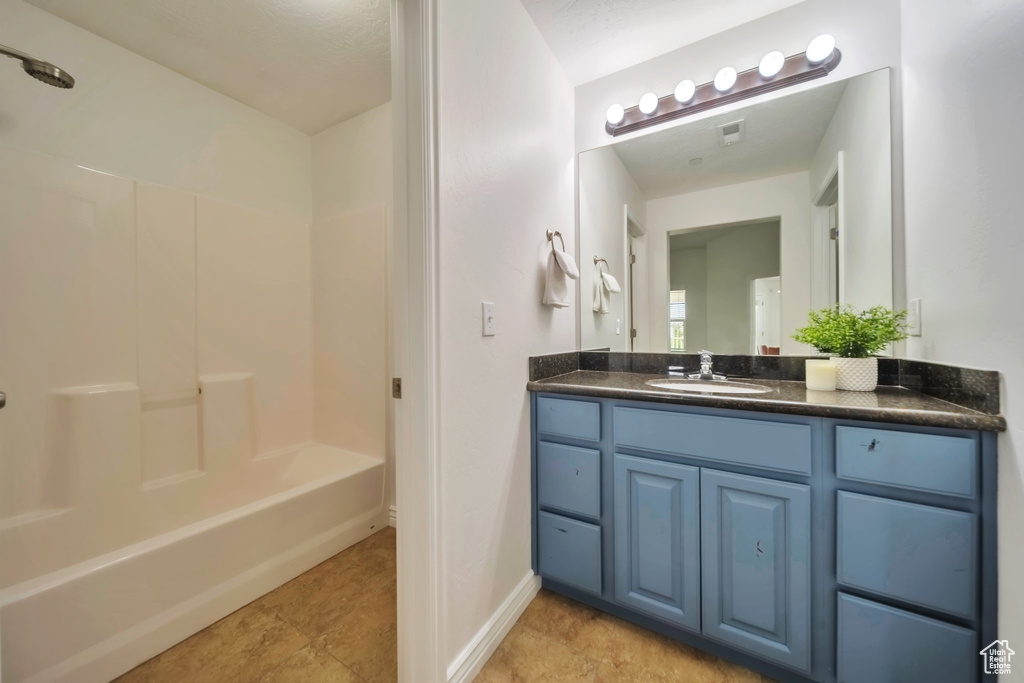 Full bath with vanity, shower / washtub combination, baseboards, and tile patterned flooring