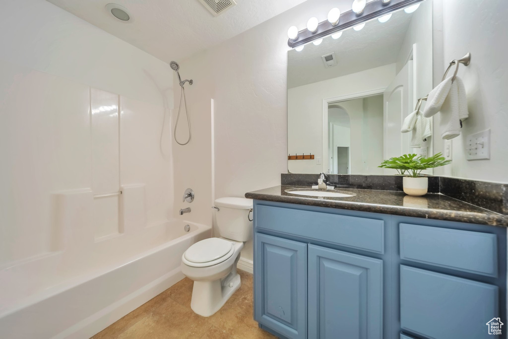 Bathroom featuring toilet, vanity, bathing tub / shower combination, and tile patterned floors