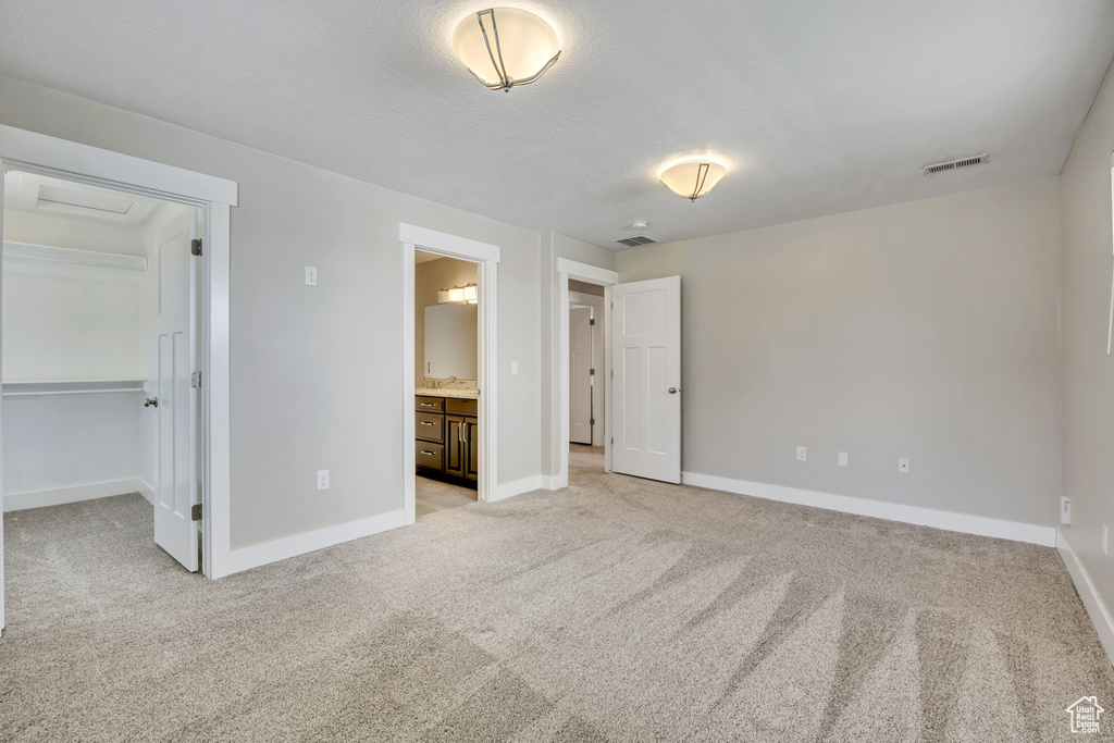 Unfurnished bedroom featuring light colored carpet and baseboards