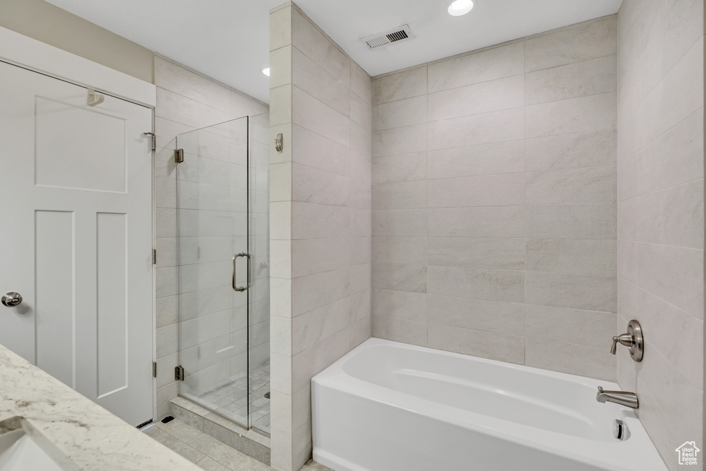 Bathroom featuring a shower stall, a bath, and recessed lighting
