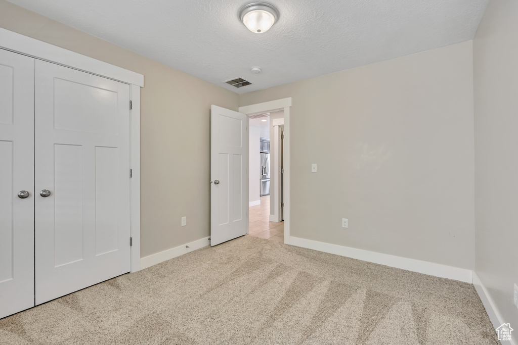 Unfurnished bedroom with carpet flooring and baseboards