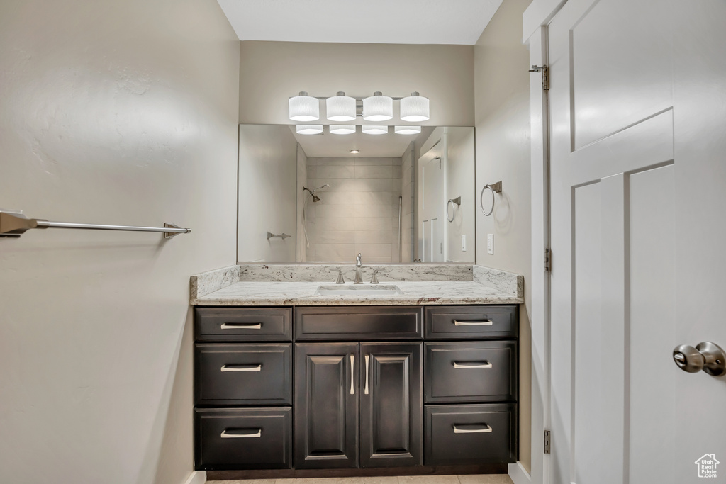 Bathroom with vanity, a shower, and baseboards