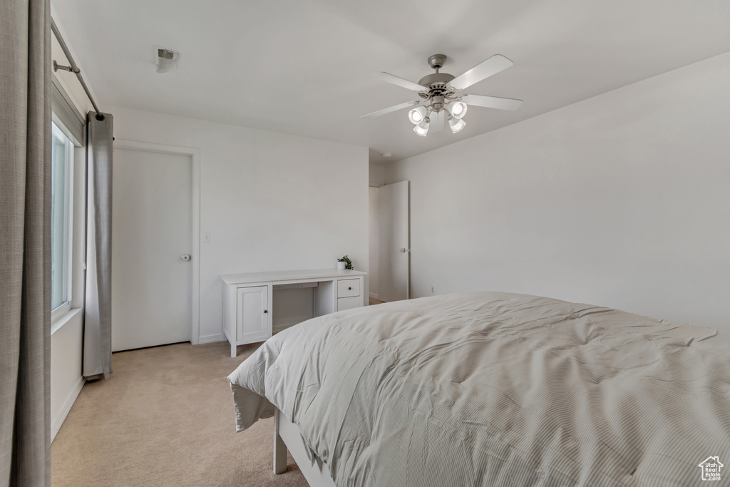 Bedroom featuring light colored carpet, a ceiling fan, and baseboards