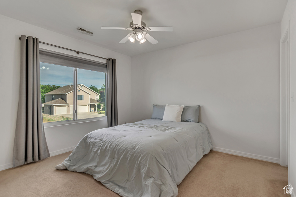 Bedroom with light carpet, baseboards, and ceiling fan