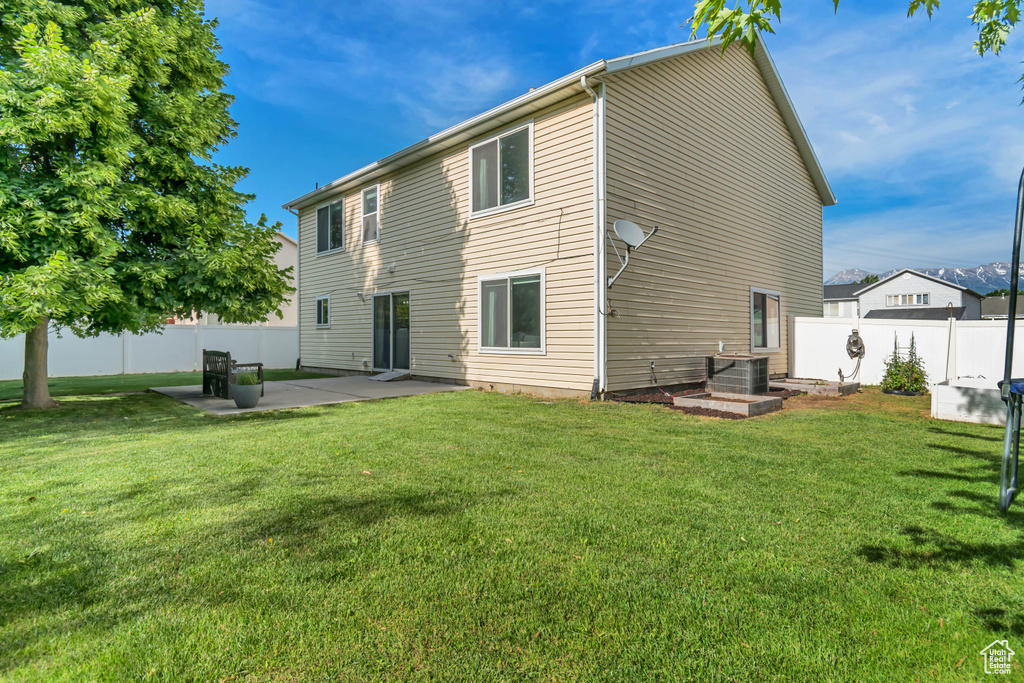 Rear view of property featuring a patio and central AC
