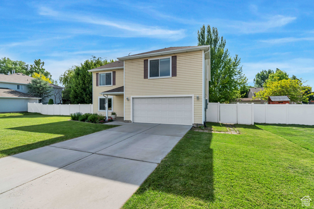 Traditional-style house featuring an attached garage and concrete driveway