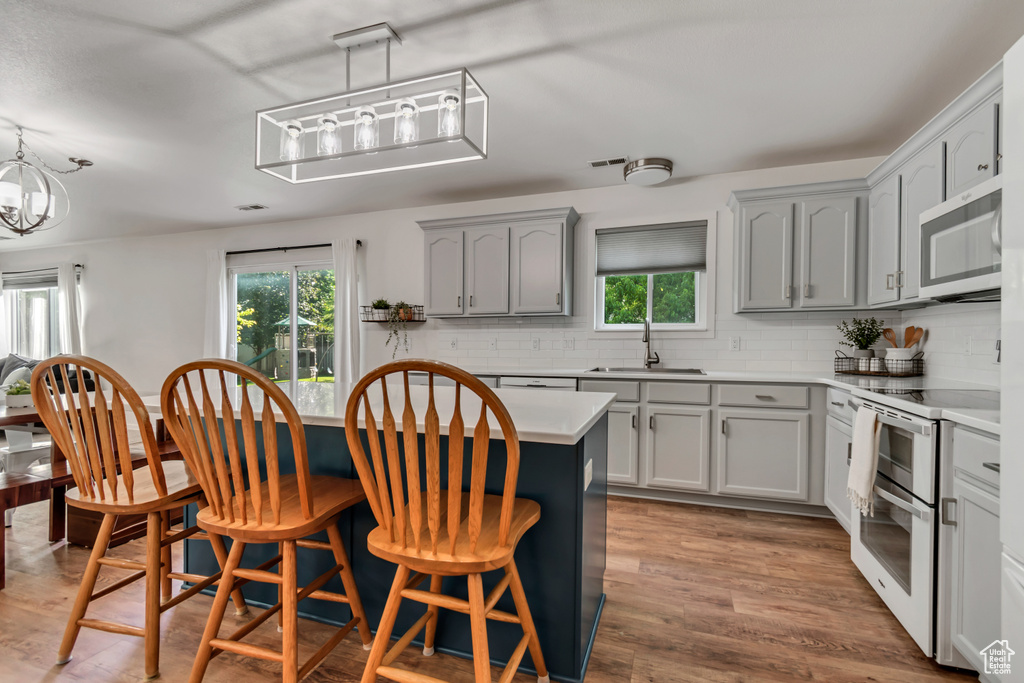 Kitchen with stainless steel microwave, double oven range, a sink, and plenty of natural light