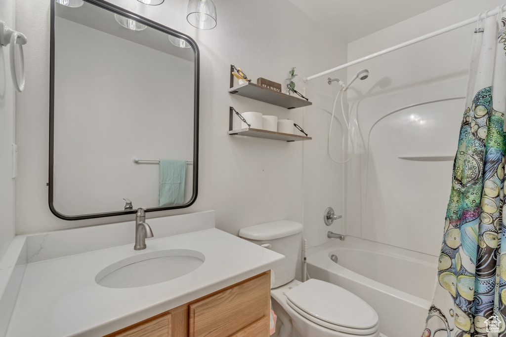Full bathroom featuring shower / bath combo, toilet, and vanity