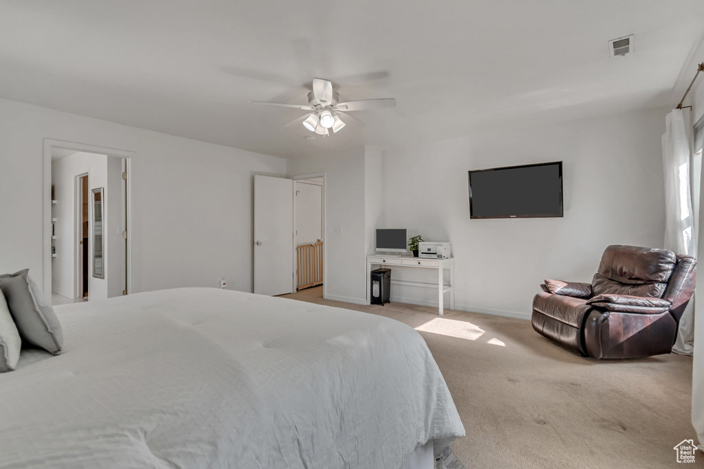 Bedroom with radiator heating unit, light colored carpet, baseboards, and ceiling fan