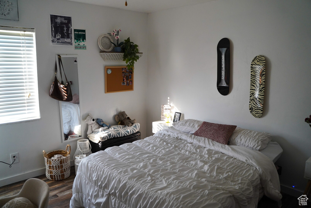Bedroom featuring wood finished floors, multiple windows, and baseboards