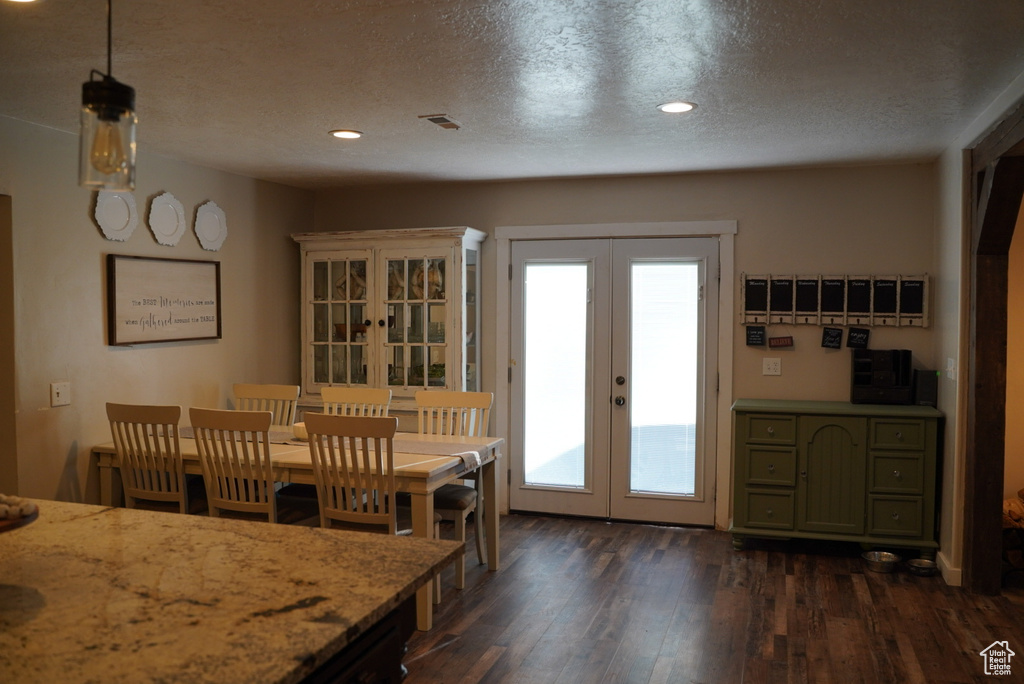 Dining room featuring french doors, dark wood finished floors, a textured ceiling, and recessed lighting