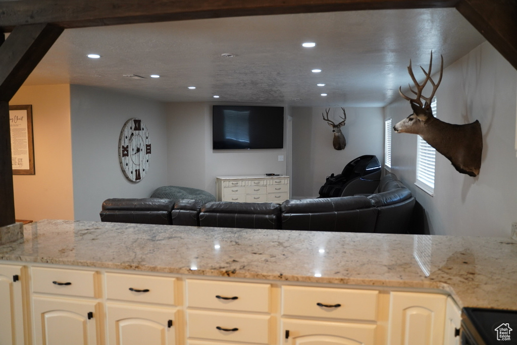 Kitchen featuring open floor plan, recessed lighting, light stone counters, and electric stove