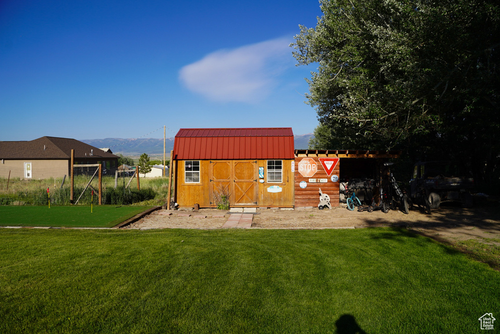 Rear view of house with a yard, metal roof, and a mountain view