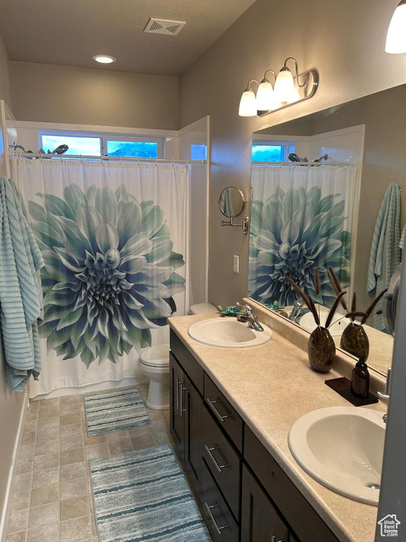 Full bath with double vanity and a shower with curtain