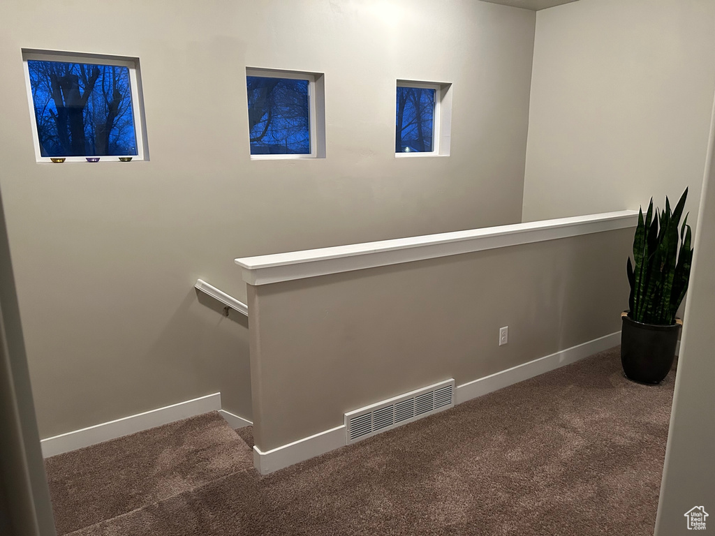 Corridor featuring carpet, baseboards, and an upstairs landing