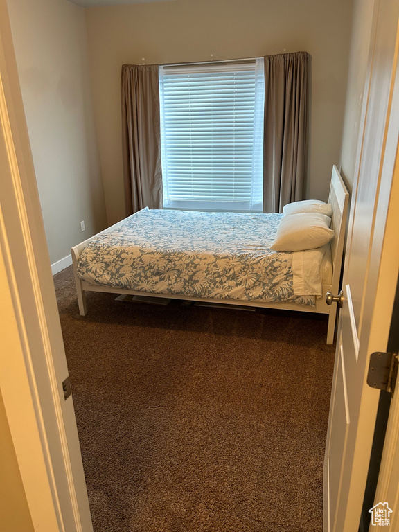 Bedroom featuring carpet and baseboards