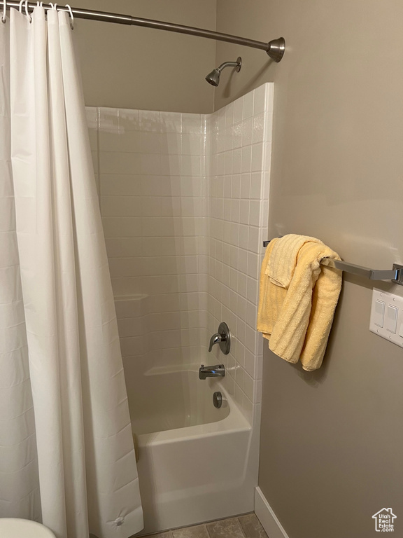 Full bath featuring shower / bathtub combination with curtain, baseboards, and toilet