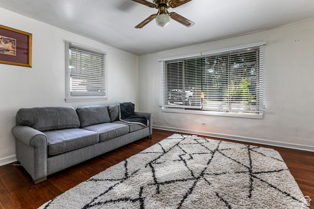 Living area with ceiling fan, wood finished floors, and baseboards