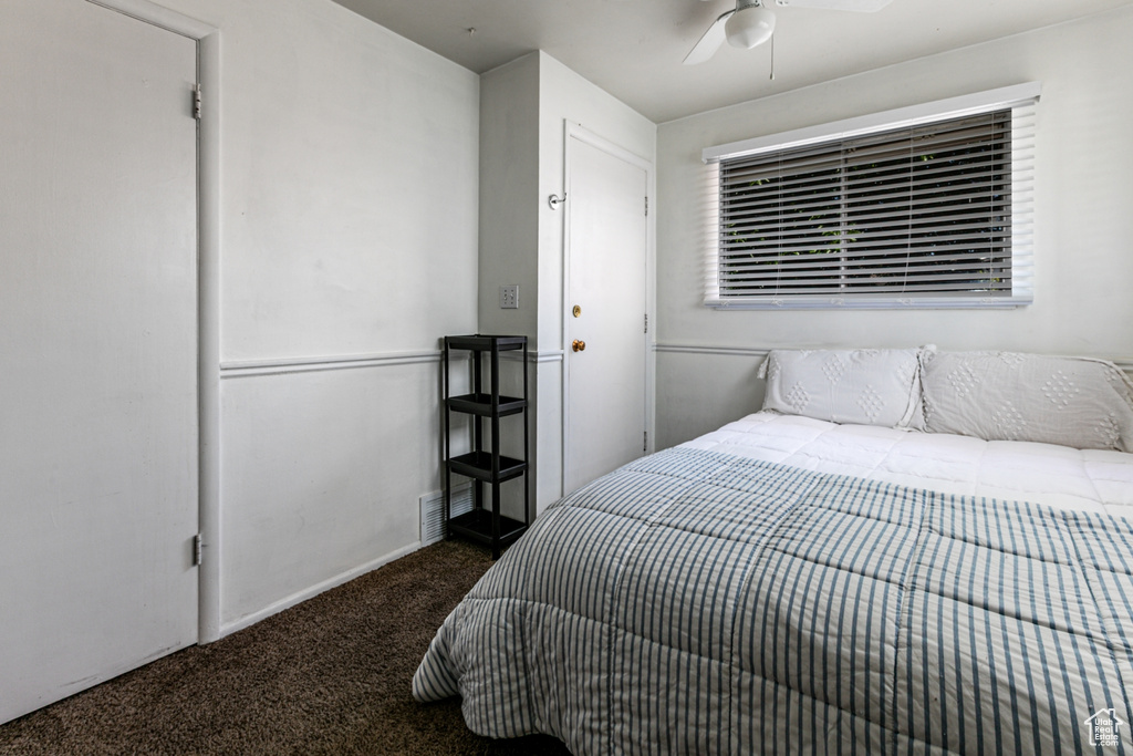 Carpeted bedroom with ceiling fan and baseboards