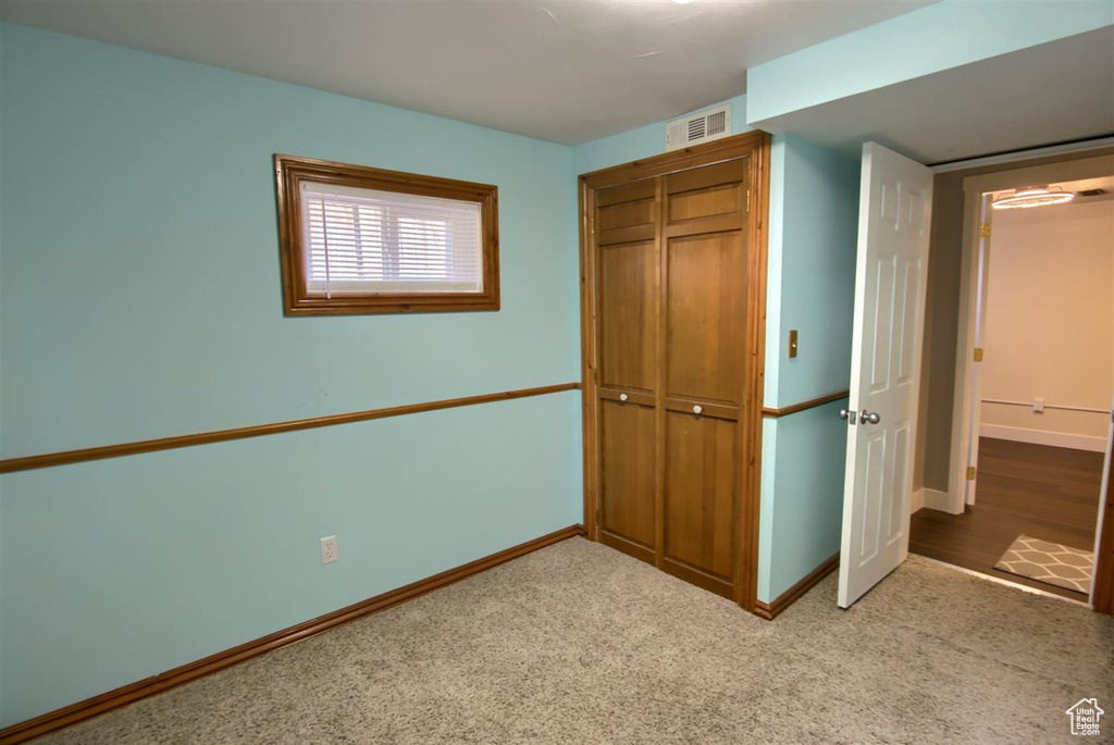 Unfurnished bedroom featuring a closet, baseboards, and carpet