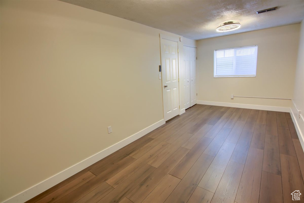 Unfurnished room with baseboards and dark wood-style floors