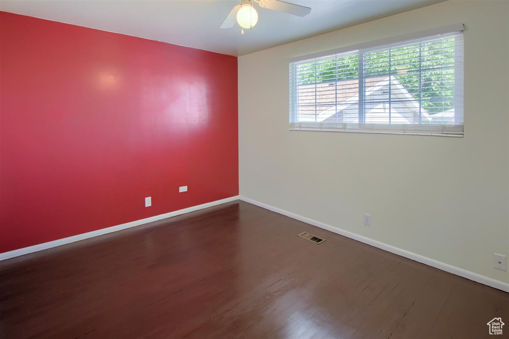 Empty room featuring baseboards, wood finished floors, and ceiling fan