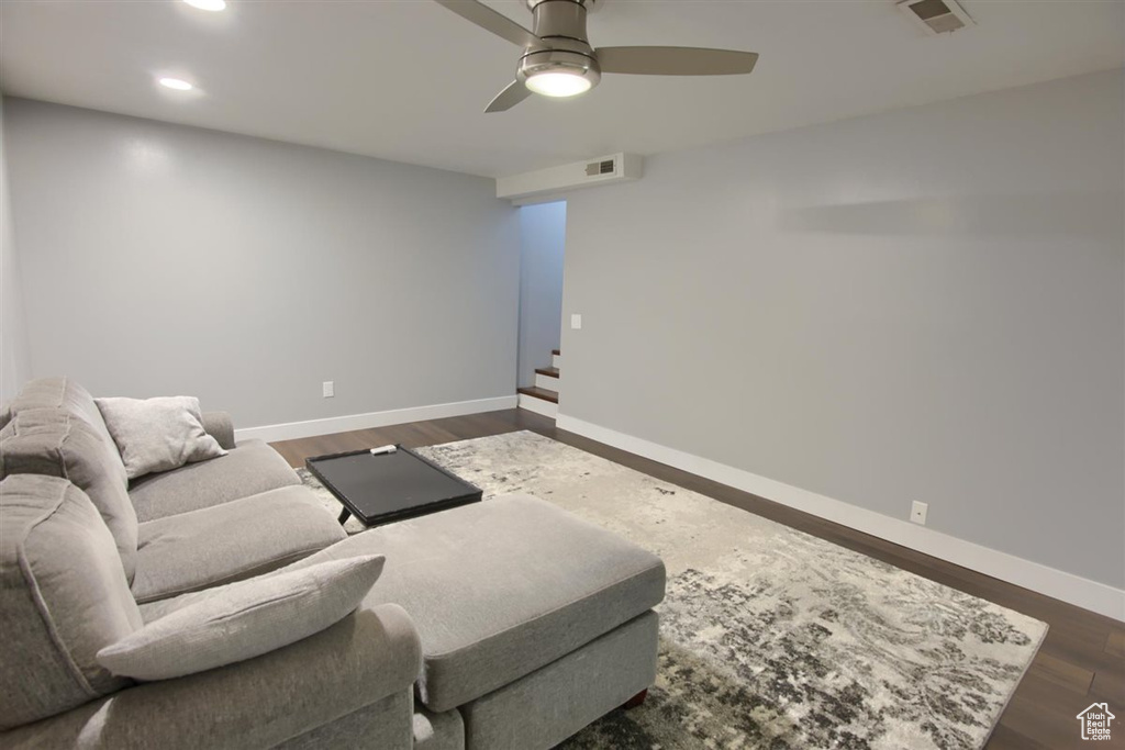 Living room featuring baseboards, dark wood finished floors, a ceiling fan, recessed lighting, and stairway