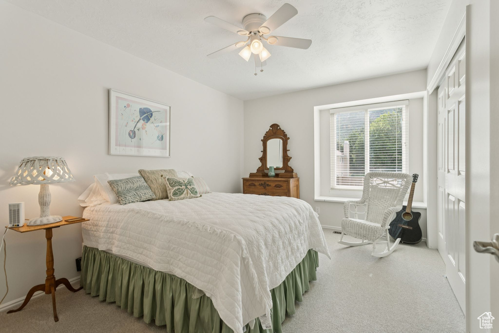 Carpeted bedroom with baseboards and a ceiling fan