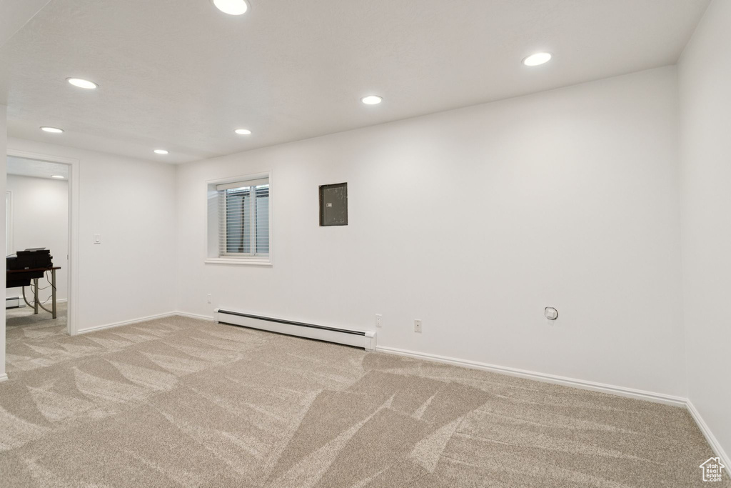 Spare room with baseboard heating, light carpet, recessed lighting, and baseboards