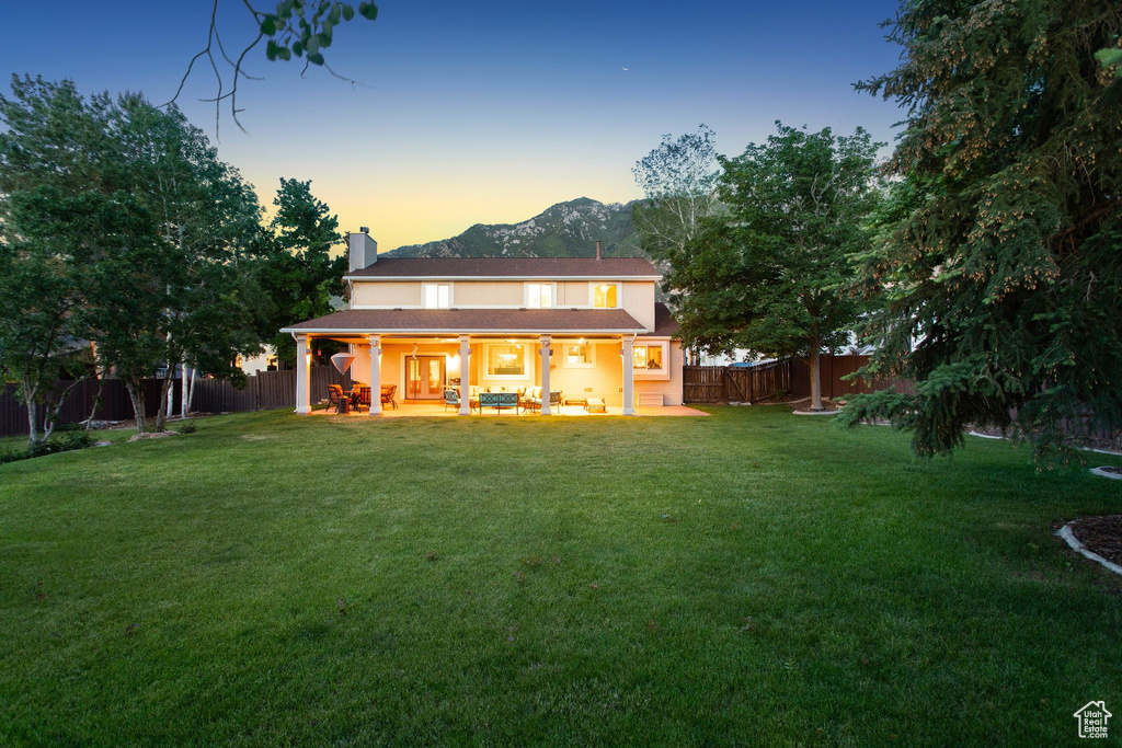 Rear view of property featuring a chimney, a mountain view, and a patio area