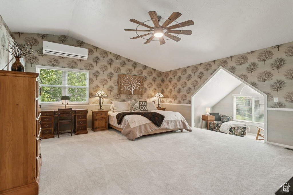 Bedroom with a wall mounted air conditioner, lofted ceiling, light colored carpet, wallpapered walls, and ceiling fan