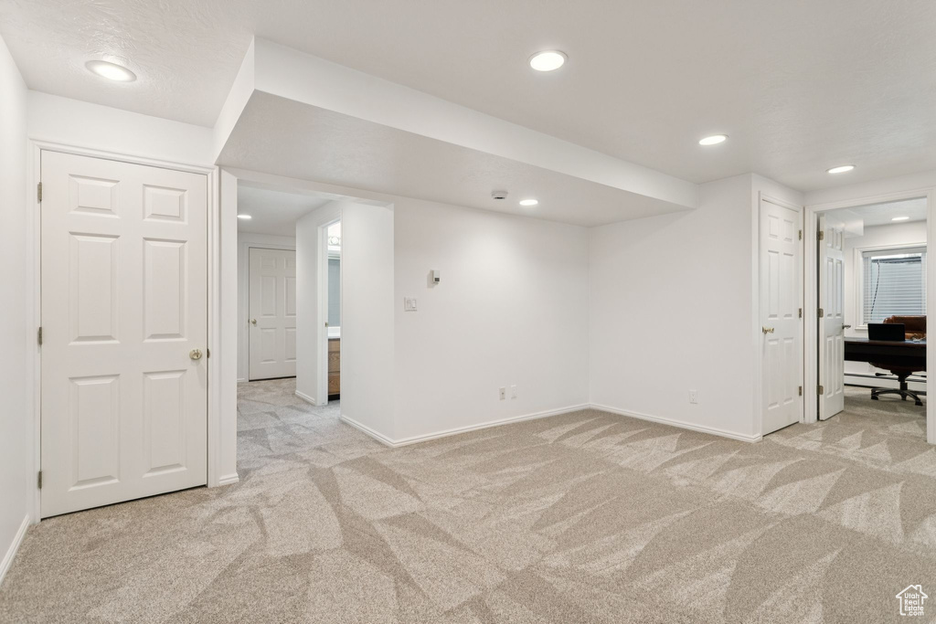 Finished below grade area with light carpet, baseboards, and recessed lighting