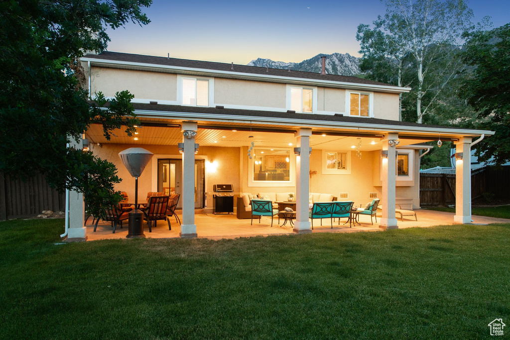 Back of property featuring stucco siding, outdoor lounge area, a mountain view, and a patio area