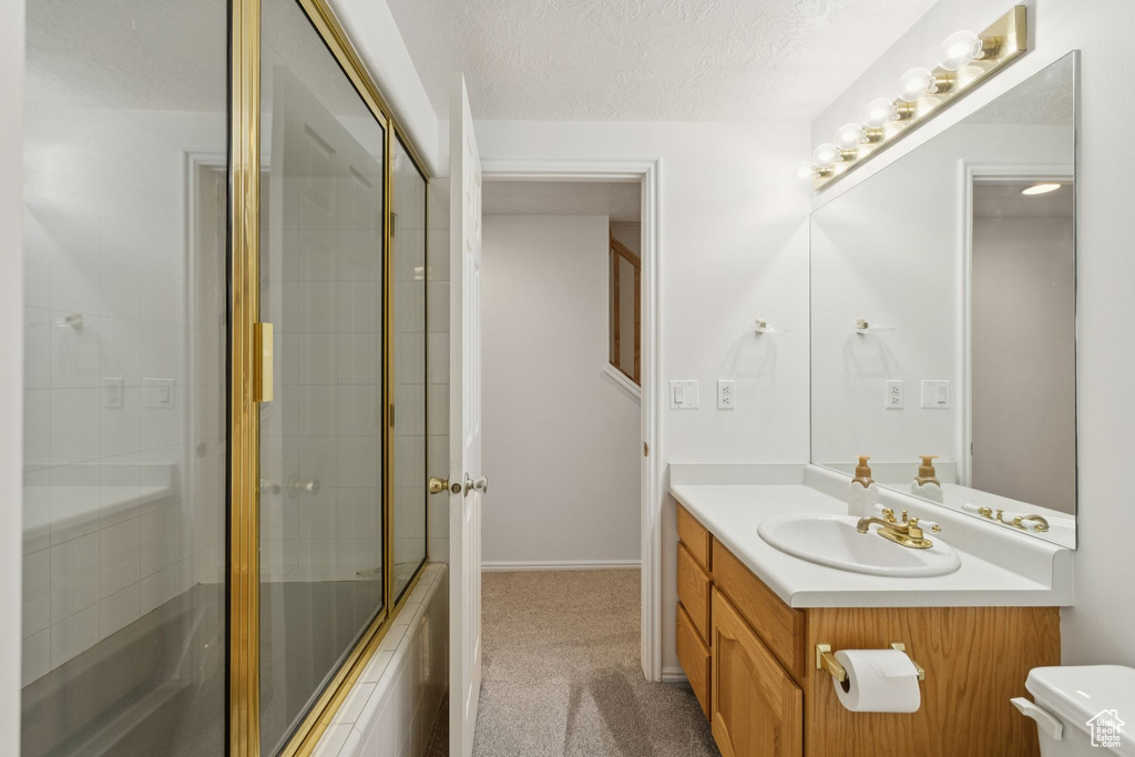 Bathroom with vanity, toilet, and a textured ceiling