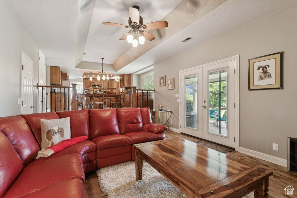Living room featuring baseboards, wood finished floors, plenty of natural light, and a raised ceiling