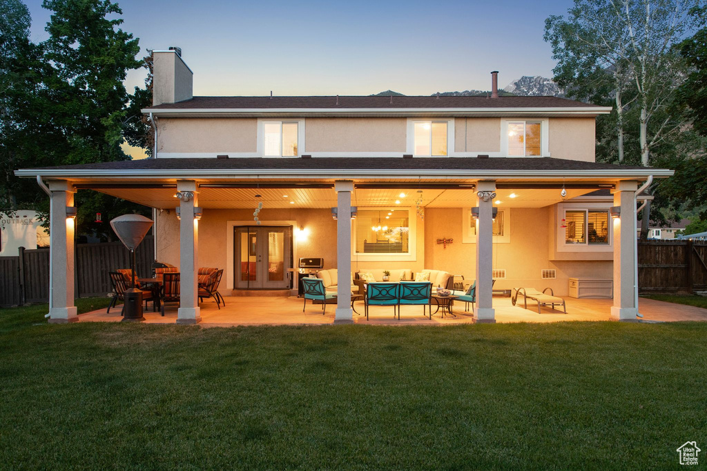 Rear view of property with outdoor lounge area, stucco siding, a chimney, and french doors