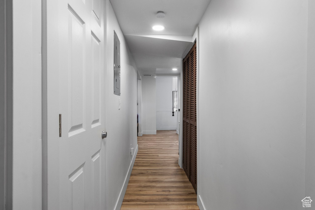 Corridor with baseboards, wood finished floors, and recessed lighting