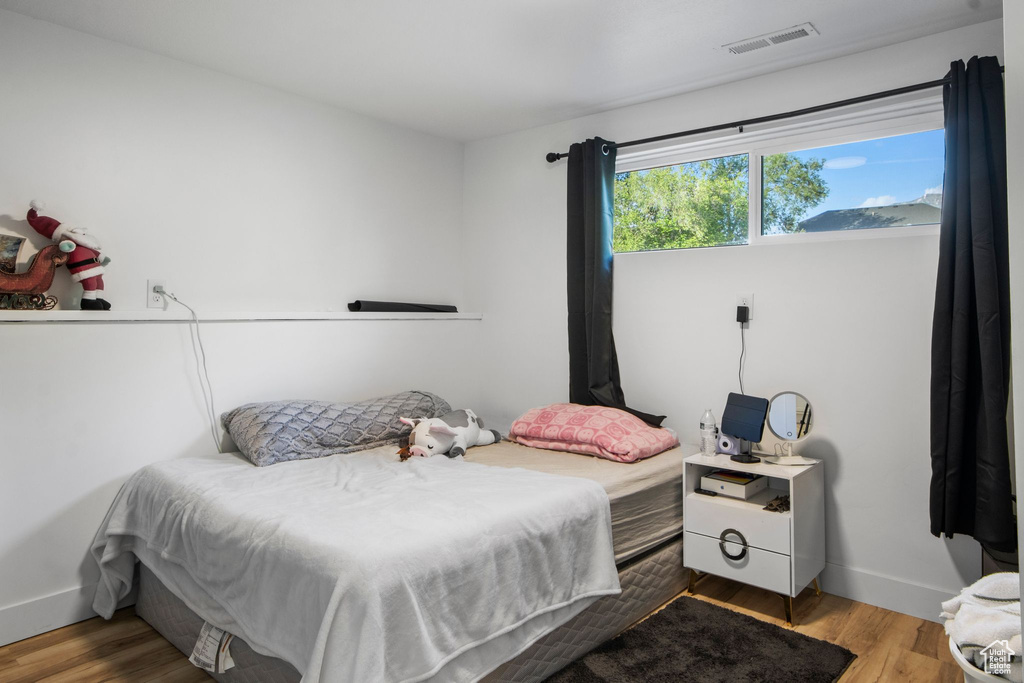 Bedroom with wood finished floors and baseboards