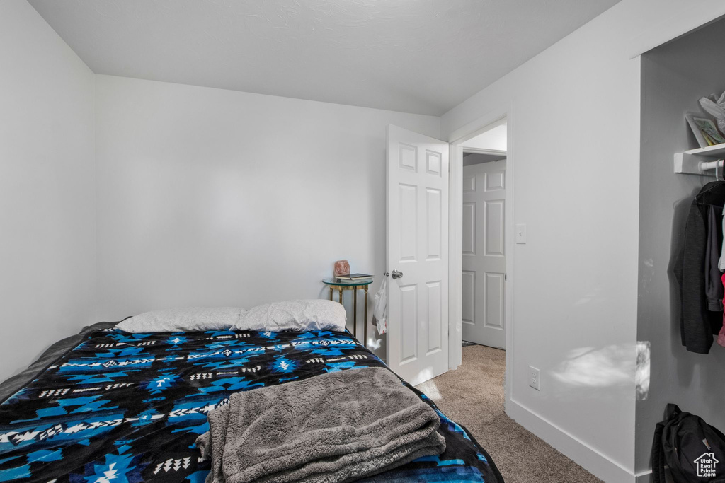 Bedroom featuring carpet floors and baseboards