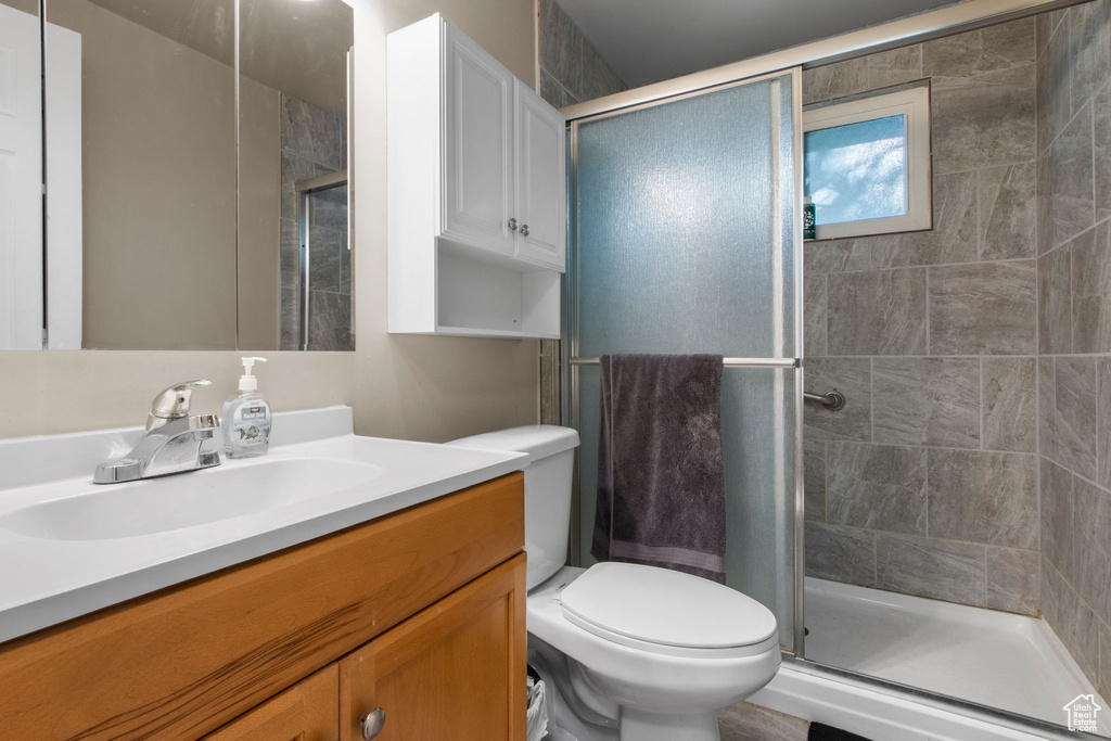 Bathroom with vanity, a stall shower, and toilet