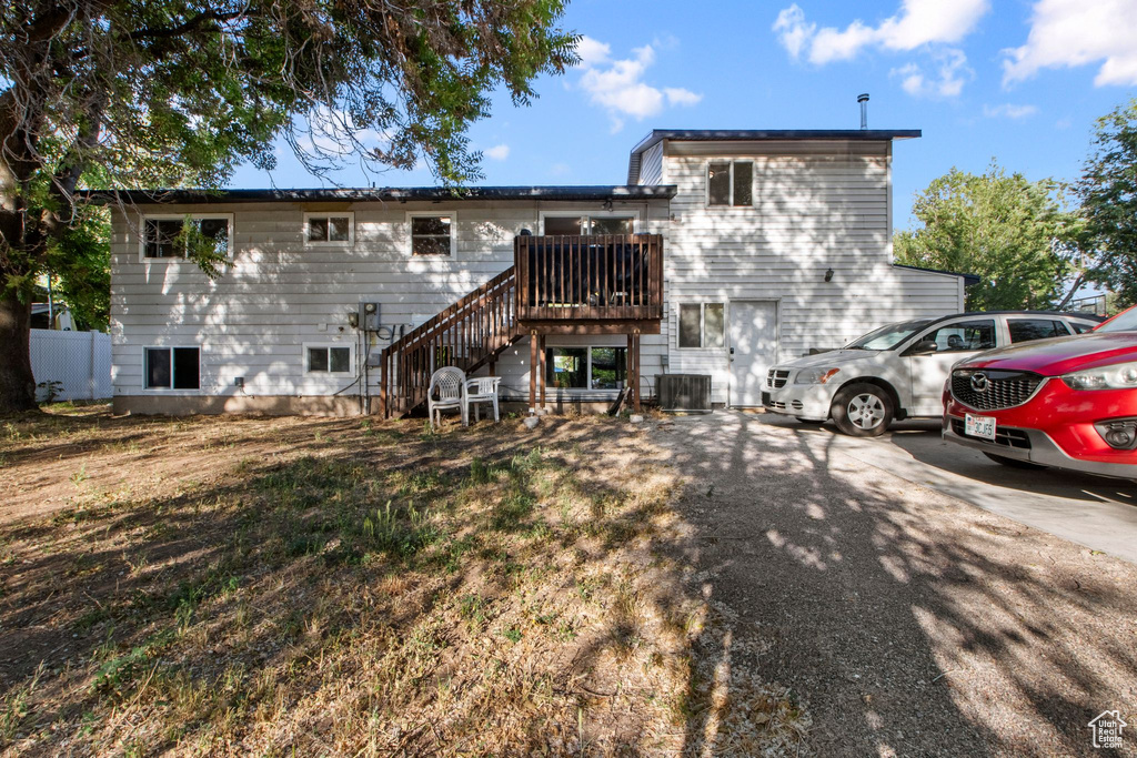 Rear view of house with stairway and central AC unit