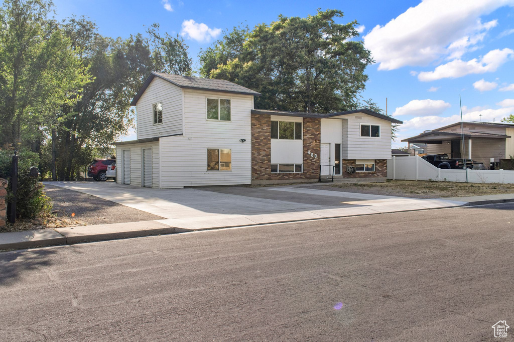 View of front of home with a garage, driveway, and brick siding