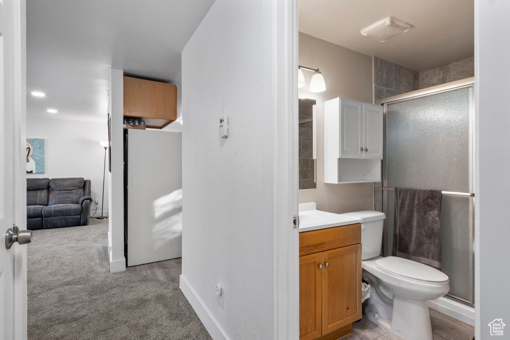 Bathroom with vanity, a shower stall, toilet, and baseboards