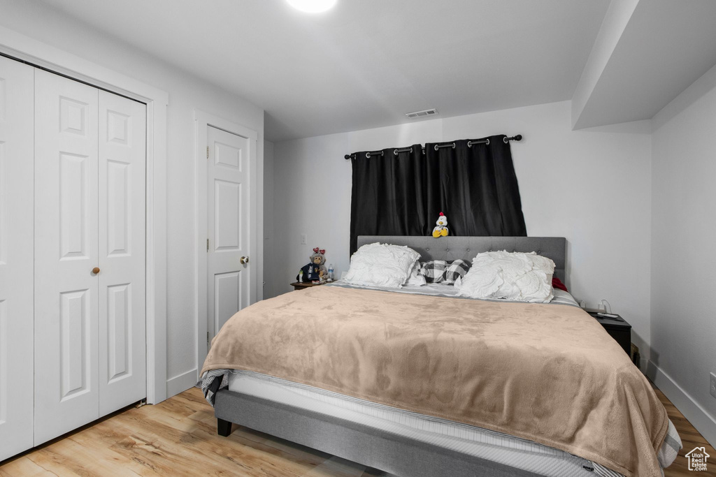 Bedroom featuring wood finished floors and a closet