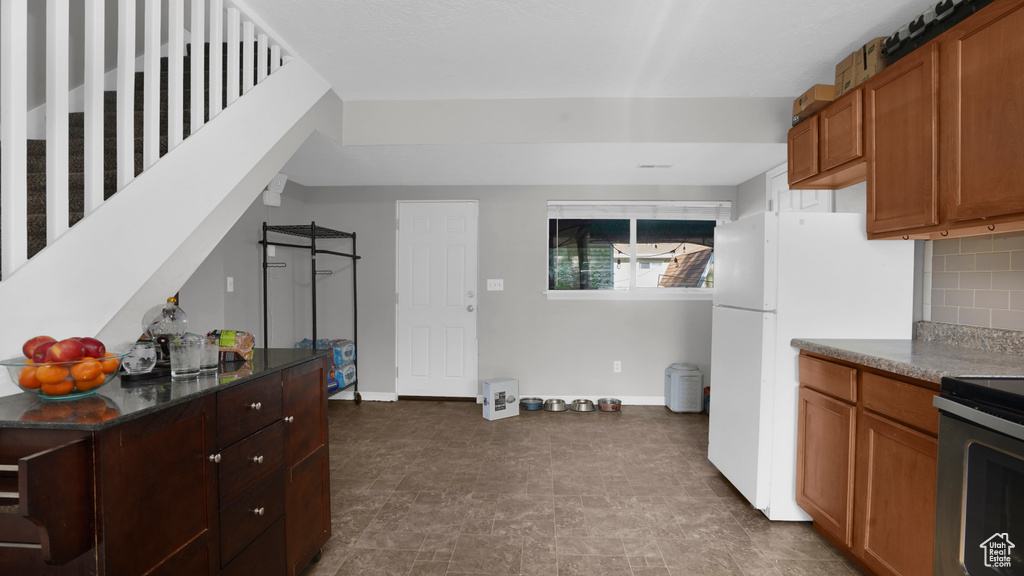 Kitchen with dark countertops, tasteful backsplash, and baseboards