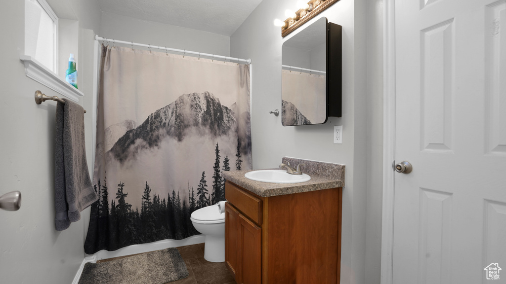 Bathroom featuring vanity, toilet, a shower with curtain, and tile patterned flooring
