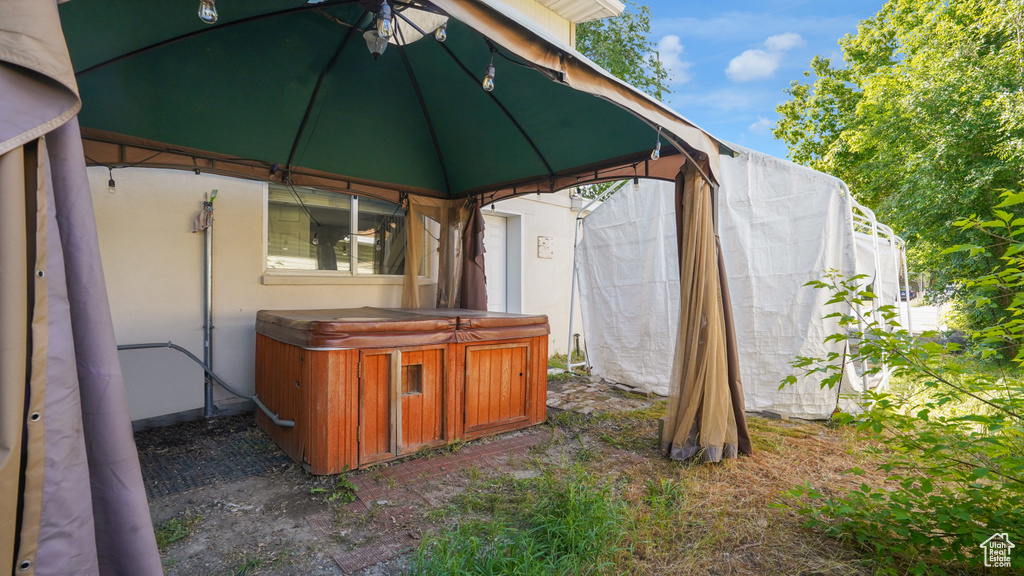 View of outbuilding featuring a hot tub and a gazebo