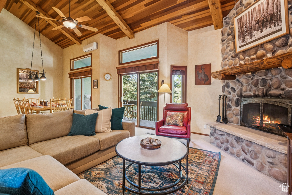 Living area with wooden ceiling with exposed beams, high vaulted ceiling, ceiling fan, carpet flooring, and a fireplace